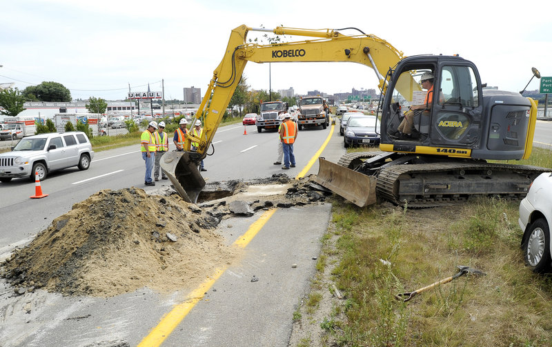 A Maine Department of Transportation crew works on repairing a sinkhole about 4 feet deep in a northbound lane of I-295, just before Tukey’s Bridge in Portland. Traffic was delayed about three hours Wednesday afternoon before crews were able to fill the hole temporarily.