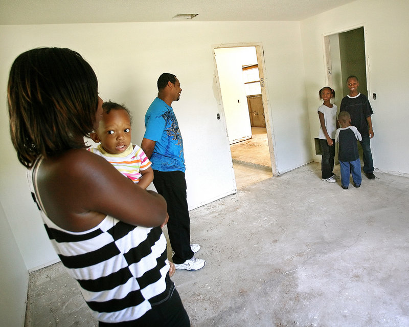 Bruce and Gizzel Stephens tour their future home with four of their children, Shyann, 1, Natalia, 8, Darnell, 3, and Malik, 12. Habitat for Humanity is remodeling a foreclosed home for the family of seven. For Habitat, the rehabbed foreclosures are less expensive than new construction.