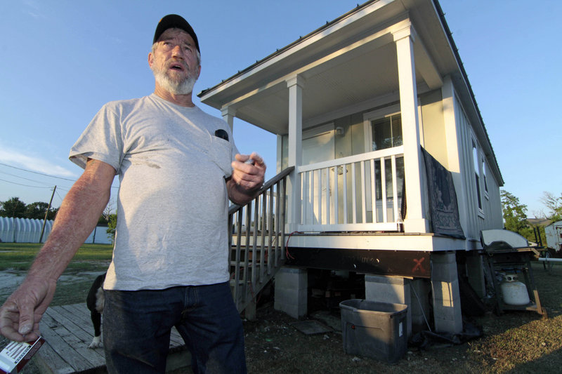Pete Yarborough speaks in front of his 400-square-foot cottage in Lakeshore, Miss. He can buy the cottage for $351, but it would cost about $23,000 to raise it in the flood-prone area. If he doesn’t buy it, the state will evict him.