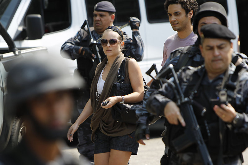 Police stand guard as tourists leave the Intercontinental Hotel in Rio de Janeiro after it was invaded by gunmen Saturday. "It seemed as if I was in Iraq," said a resident of the Sao Conrado neighborhood who was awakened by the shootout.