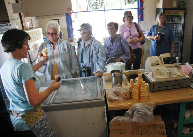 Johanna Corman serves ice cream and other treats to a crowd of ferry passengers at Pearls Seaside Market on Cliff Island. The Cormans bought the store two years ago.