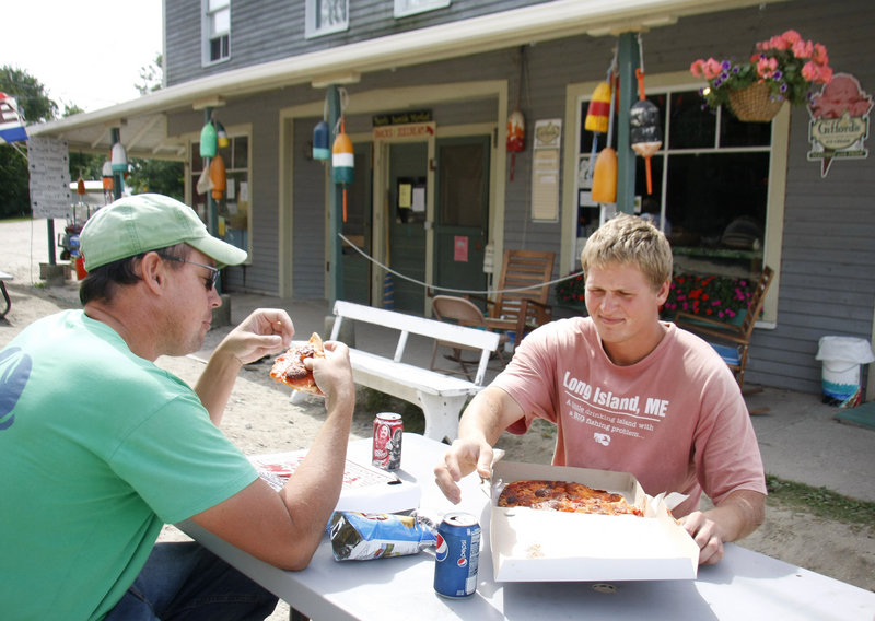 Steve Train, left, of Long Island, captain of the lobster boat Hattie Rose, and Alex Anderson, also of Long Island and sternman on Hattie Rose, stop for pizza they special ordered at Pearls Seaside Market.