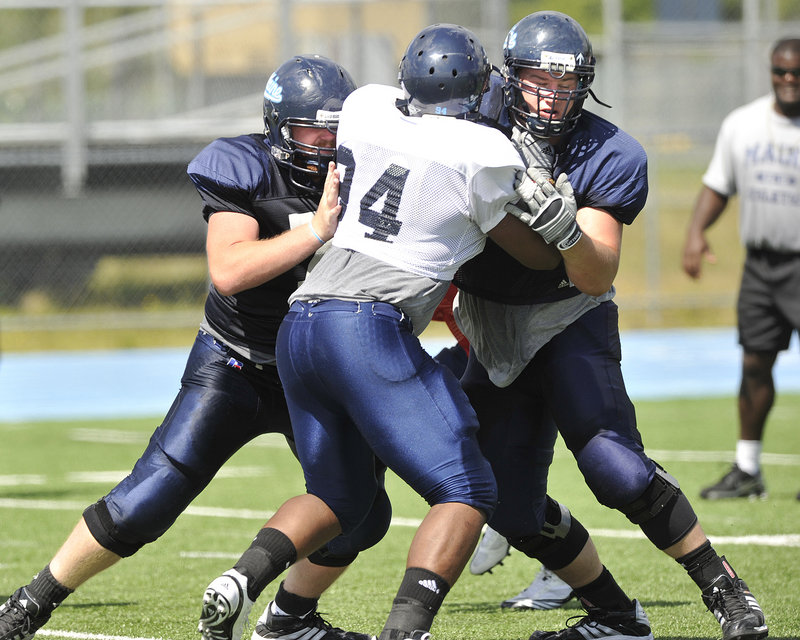 University of Maine offensive linemen William Martin, left, and Steve Shea, right, double-team block Adam Copp during a recent football practice in Orono. Four of the Black Bears’ five interior offensive linemen return from the 2009 squad.