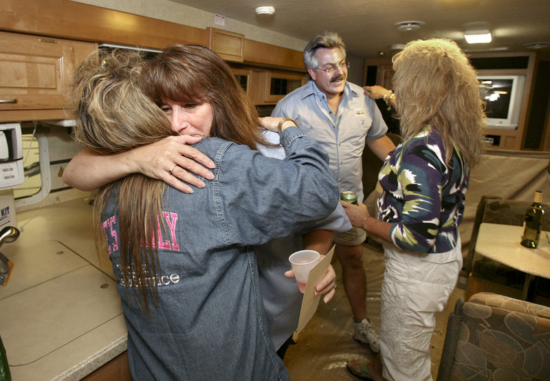Karen Jones hugs Julie Gardner of Lee's Family Trailers in Windham as her husband Wayne prepares to embrace Lee's general manager Sheri Huff.