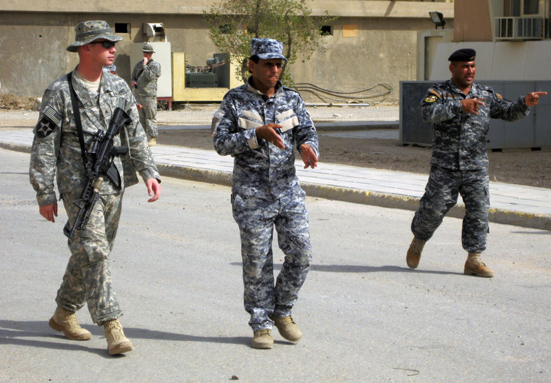 U.S. Army Sgt. Billy Bennett shows Iraqi police officers how to walk in a “wedge” formation during an exercise. The number of U.S. soldiers in Iraq dipped below 50,000 on Tuesday, a week ahead of a deadline, fulfilling a campaign pledge by President Obama to shift from fighting to a new training mission.