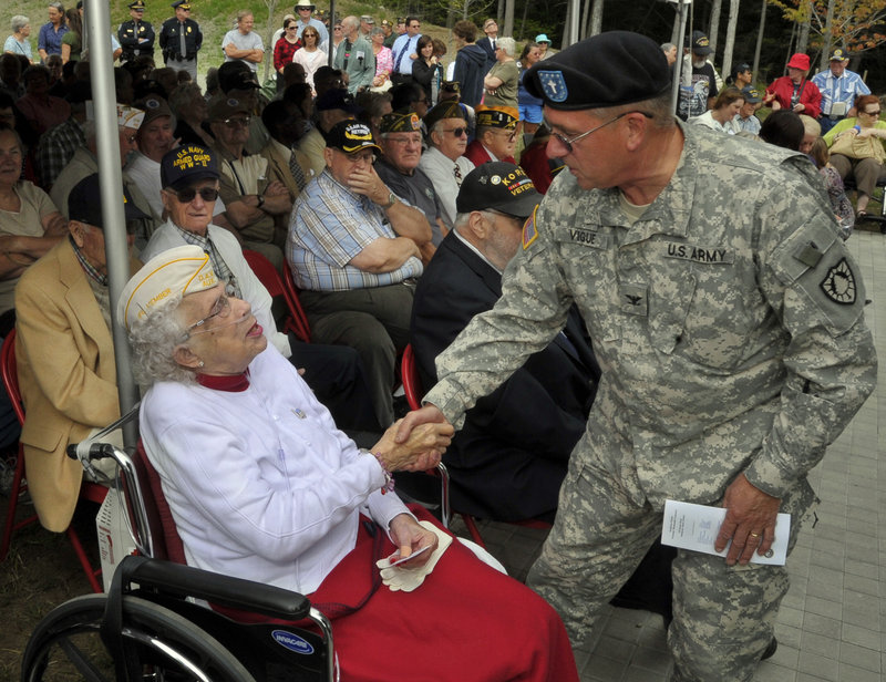 Marie Clancy, left, who is credited with keeping alive the idea of a military cemetery in southern Maine, is thanked by Col. Valmore Vigue, chaplain for the Maine Army National Guard, before the dedication of the Southern Maine Memorial Veterans Cemetery in Sanford on Tuesday. The main road into the cemetery will be named for Clancy.
