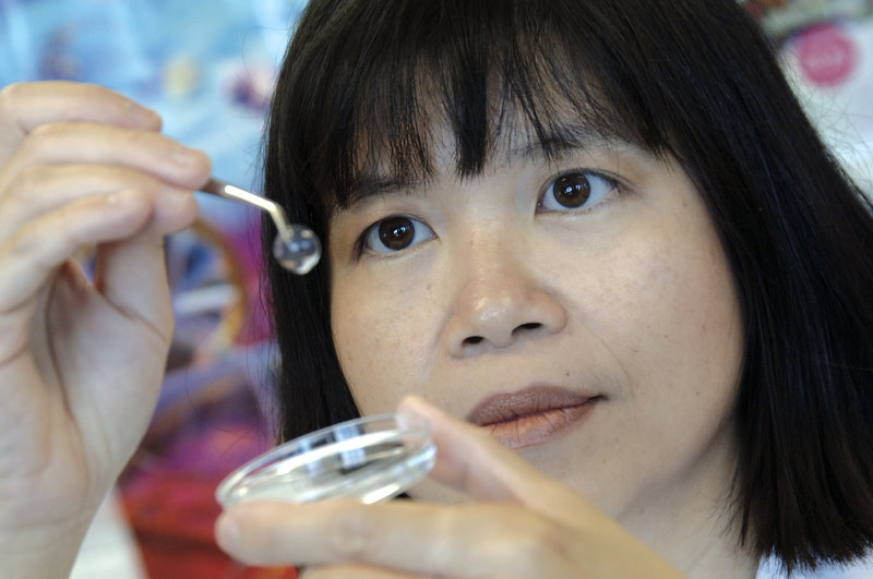 Dr. May Griffith of the Ottawa Hospital Research Institute of Canada displays a bioartificial cornea that can be implanted into the eye to restore sight.