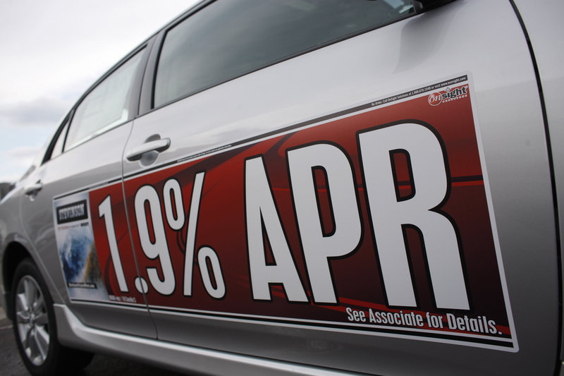A low-interest rate banner hangs on the side of an 2010 Toyota Corolla at a dealership in Lakewood, Colo. Car owners often pay far more than necessary for financing, but auto loans, like mortgages, can be refinanced.
