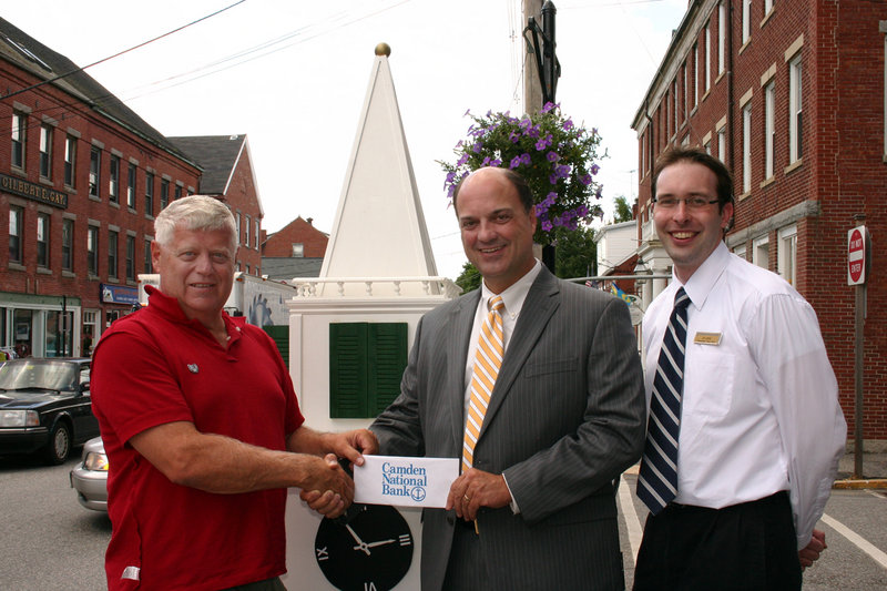 Walter Hilton, left, chairman of the Landmark Steeple & Clock Restoration Fund, receives a check from Greg Dufour, center, and Jim Jarvis, right, both of Camden National Bank.