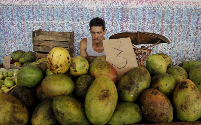A fruit vendor awaits business at a market in Havana on Friday. He’ll be able to sell from home under new commerce rules.