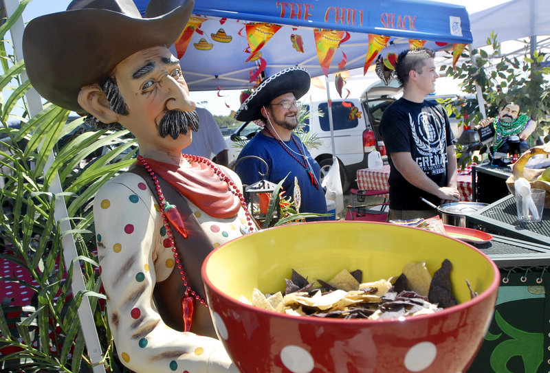 Paul and Cameron Williams of Scarborough serve chili to visitors during the Southern Maine Regional Chili Cook-off Sunday. Offering chips in the foreground is a character the Williamses referred to as “Slim Density.”