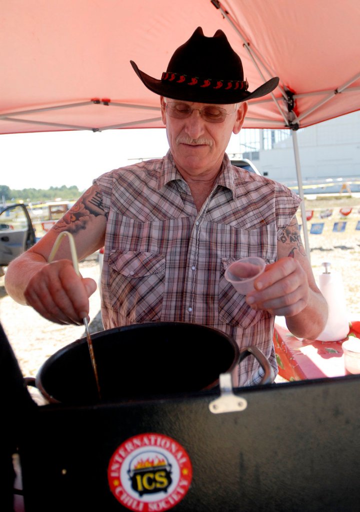 Dave Schulman of Avon, Conn., serves chili during the cook-off at Scarborough Downs. Competitors included 18 members of the International Chili Society and 17 others.
