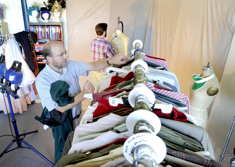 Reporter Ray Routhier looks through racks of costumes with Jacob Freund, who runs a costume rental business for the Maine State Music Theatre in Brunswick. The costumes are grouped by show and are rented to theaters nationwide.