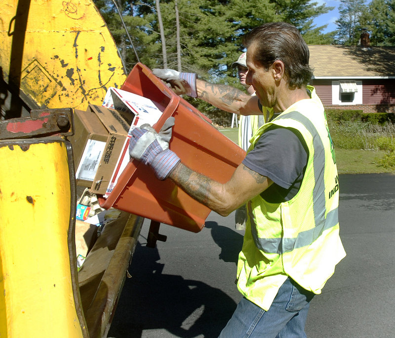 Sanford sanitation worker Steve Shaw dumps recyclable items.