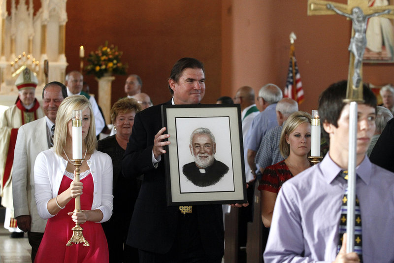 Michael Ginart carries a portrait of his uncle, the Rev. Arthur Ginart, in a procession after a memorial service in the Resurrection of Our Lord Church in New Orleans on Aug. 21. The priest is presumed to have drowned after he chose not to evacuate from his church before Katrina struck in 2005.