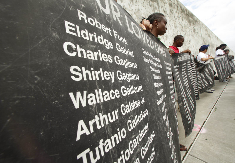 People hold up a banner bearing the names of those who died in Hurricane Katrina, in front of the Industrial Canal floodwall during a public commemoration of the fifth anniversary of the hurricane in New Orleans’ Lower 9th Ward on Sunday.