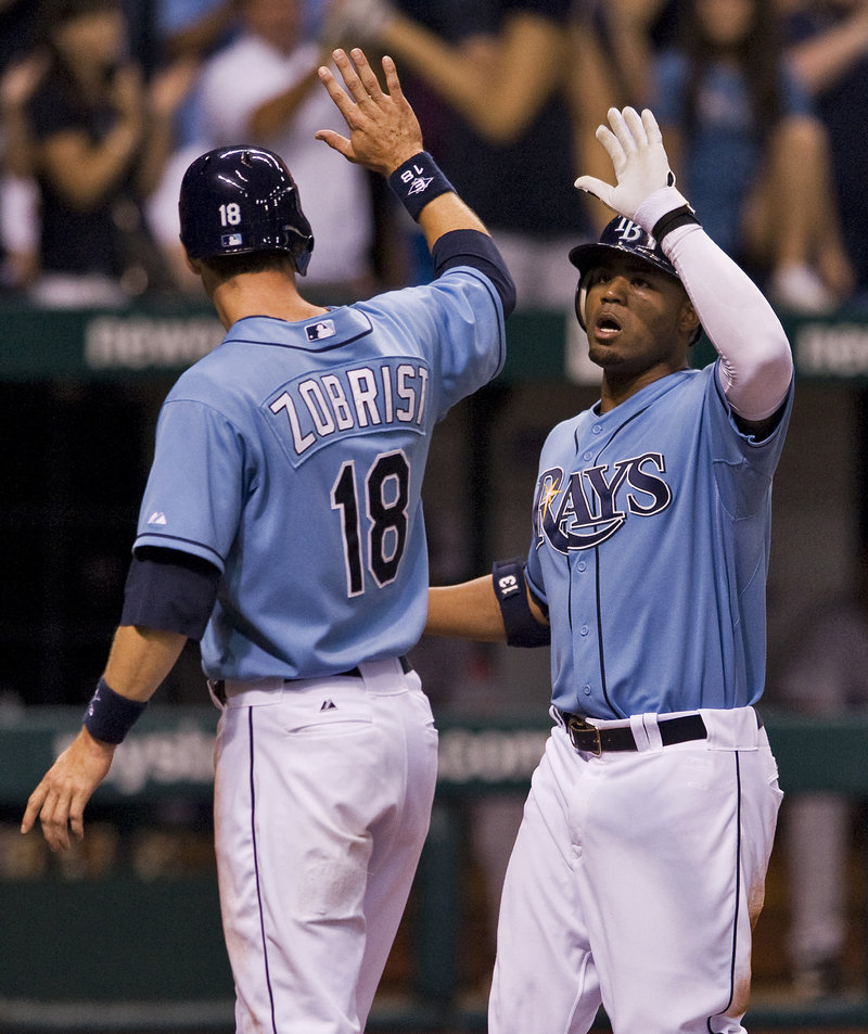 Ben Zobrist, left, congratulates Rays teammate Carl Crawford after scoring on Crawford’s two-run homer in the sixth inning.
