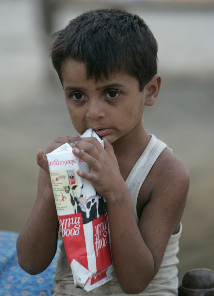 A boy chews on an empty milk carton Monday at a camp for people displaced by floods at Hazrat Mosa Wala in Punjab province, Pakistan. The floods are one of the biggest disasters in recent world history.