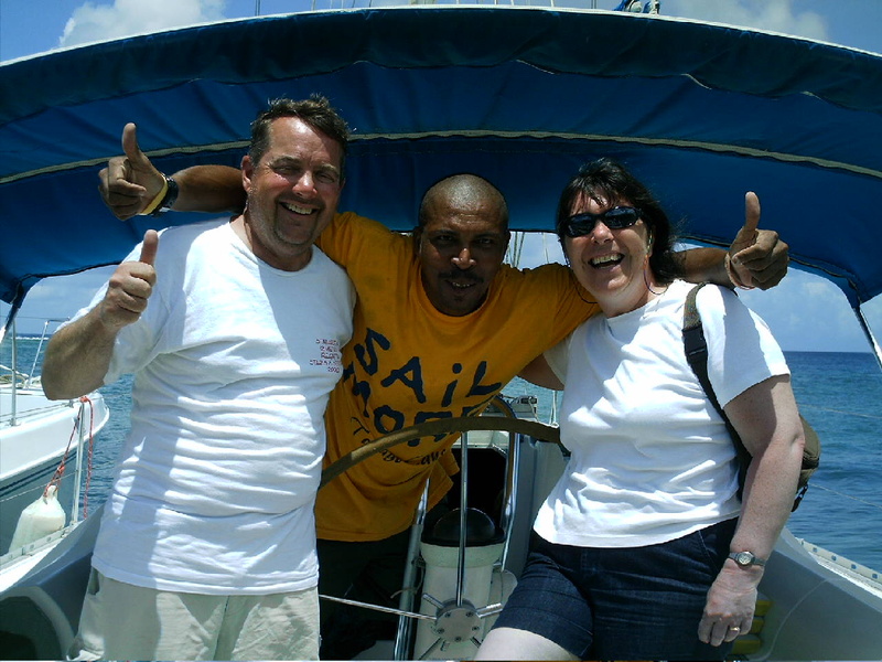 Tim Reardon, the author's husband, and Miriam Gough pose with Seymour, the skipper at the Barefoot Charters sailing school.