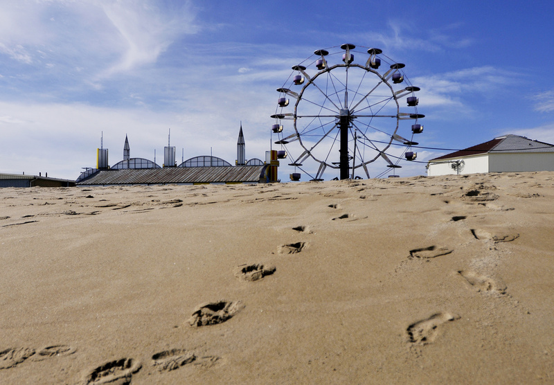 Footsteps in the sand lead away from Palace Playland in Old Orchard Beach on Tuesday. The crowds are mostly gone on the beach and the rides are closed until next season, but the amusement park’s large arcade will be open weekends through Columbus Day.