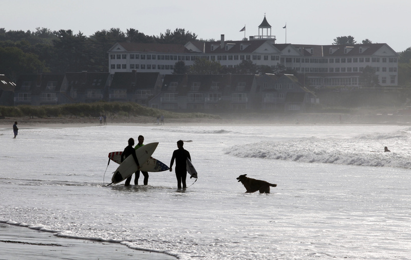 Surfers prepare to head out to take advantage of the waves churned up by Tropical Storm Earl today off of Gooch's Beach in Kennebunk