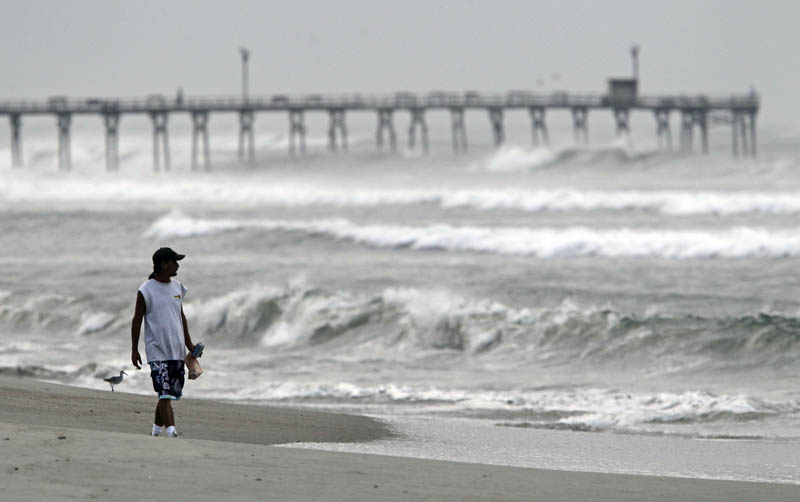 Almon Telling looks at the surf as he walks along the beach in Atlantic Beach, N.C., today.