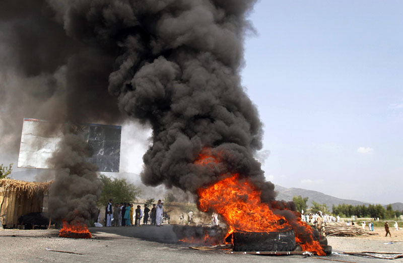 Afghans burn tires and block a highway during a protest, in reaction to a small American church's plan to burn copies of the Quran, at Jalalabad, east of Kabul, Afghanistan today. Religious and political leaders across the Muslim world welcomed a decision by the church to suspend its plans to torch copies of their holy book but some said today the damage has already been done.