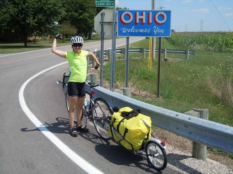 Leah Trommer of Northport celebrates reaching a new state on her cross-country bicycle trip
