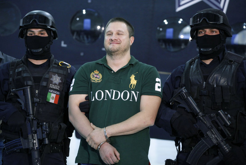 Mexican police escort Texas-born Edgar Valdez-Villarreal, alias “La Barbie,” in Mexico City on Tuesday. Valdez, the third major suspected drug lord to fall in Mexico in the past nine months, is wanted in the U.S. for allegedly smuggling tons of cocaine and is blamed for a brutal turf war in Mexico.