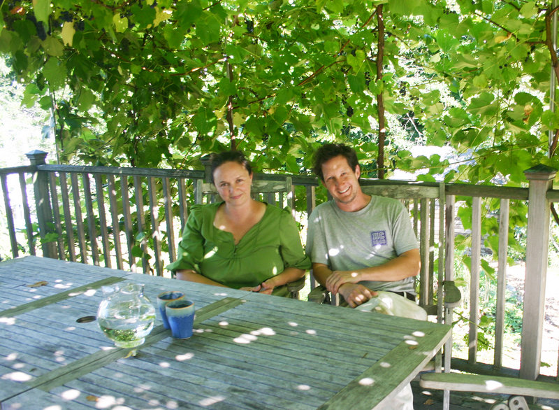 Lisa Fernandes and her husband, David Whitten, sit on their deck in Cape Elizabeth in the dappled sunshine created by the grape arbor loaded with Bluebell and Beta grapes.