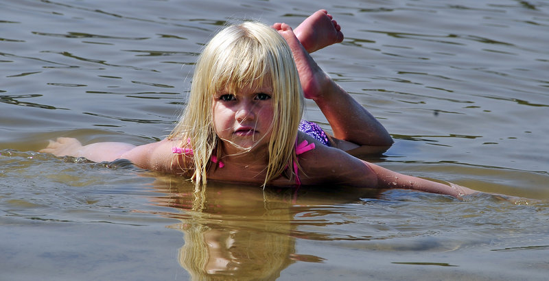 Dylan Gerrish, 4, of Naples makes waves of her own in the shallow water on Sebago Pines Association Beach in Naples on Tuesday.