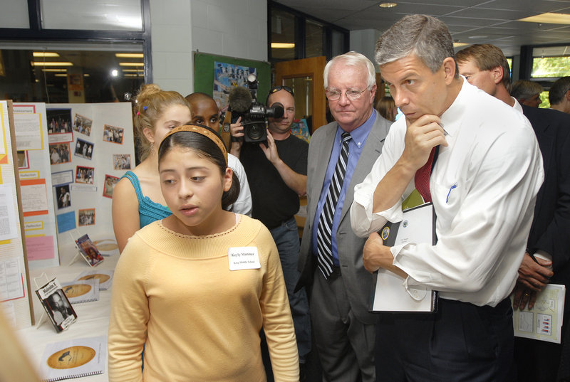 Keyly Martinez, a King Middle School eighth grader, explains her study project to U.S. Secretary of Education Arne Duncan, right, and Principal Mike McCarthy, center.