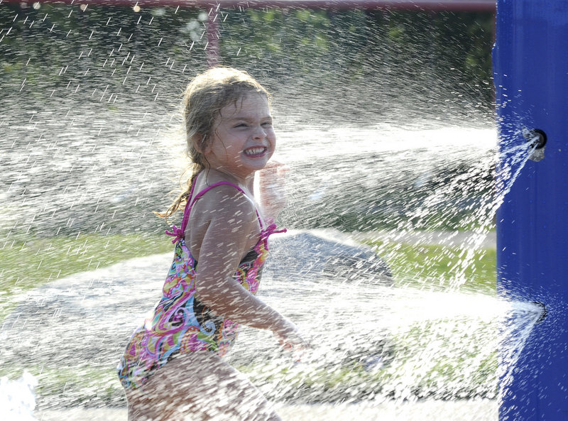 Four-year-old Makeena Wheeler of Portland lets the sprinklers cool her off at the Payson Park playground in Portland on Tuesday as temperatures surpassed 90 degrees for the third consecutive day.