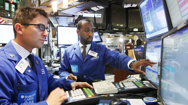 Christian Sanfilippo, Jr., left, and Dwayne Branker, with Barclays Capital, monitor the stock price at the New York Stock Exchange in New York. Stocks are forecast to continue sliding today as investors prepare for more disappointing news.