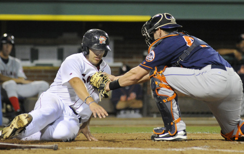 Luis Exposito of the Portland Sea Dogs is tagged out by catcher Luke Montz of the Binghamton Mets during their game Tuesday night at Hadlock Field. The Sea Dogs used strong pitching by Stephen Fife and Ryne Lawson, as well as three home runs, to come away with a 6-0 victory.