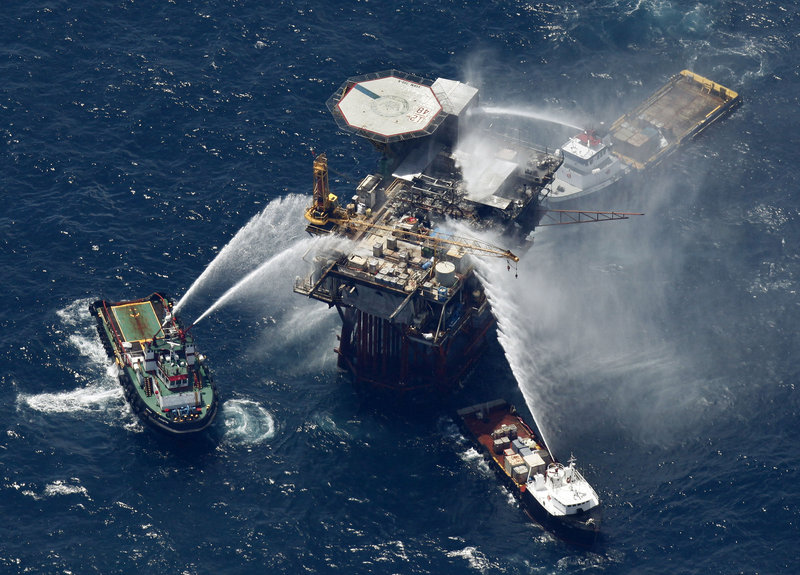 Boats spray water on a Mariner Energy oil and gas platform on Thursday in the Gulf of Mexico after a fire broke out on it. All 13 platform crew members were rescued.