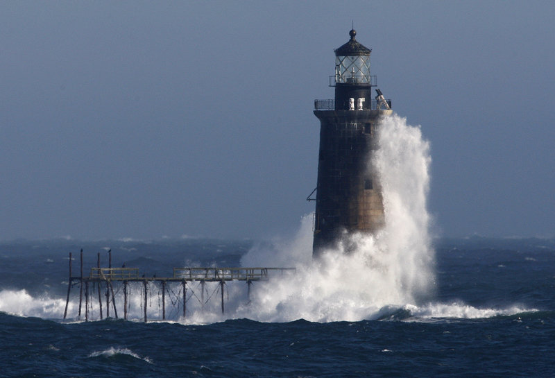 Heavy surf slams into the 72-foot-tall Ram Island Ledge Light at the mouth of Portland Harbor in December 2009. The 105-year-old lighthouse is being auctioned by the federal government.