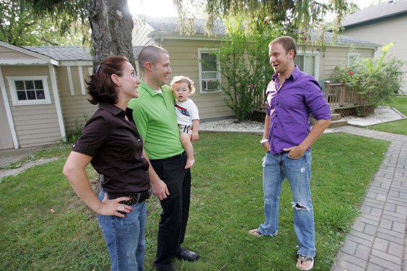 Cyndee and Jason Pote, holding their son Cooper, talk with Matthew Miles, who rented their home in Southfield, Mich. “We were able to cover our mortgage and then some,” she said.