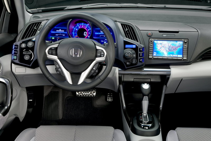 The instrument panel features bright lighting accents and a large, 3D-looking digital speedometer.