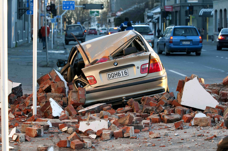 A car crushed by bricks from a building is seen after an earthquake in Christchurch, New Zealand, early today. The mayor declared a state of emergency, warning people that continuing aftershocks could cause masonry to fall from damaged buildings. Looters broke into some shops.