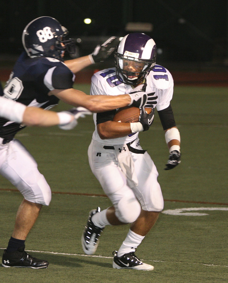 Mike Herrick, who scored a spectacular late tying touchdown on a pass for Portland, prepares to tackle Renaldo Lowry of Deering.