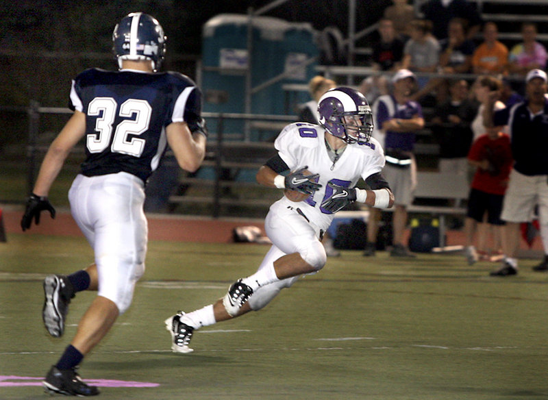 Renaldo Lowry of Deering looks for room while returning a punt Friday night as Carl Szanton of Portland closes in at Fitzpatrick Stadium. Deering, which lost its final six games last season, came from behind for a 21-14 victory.