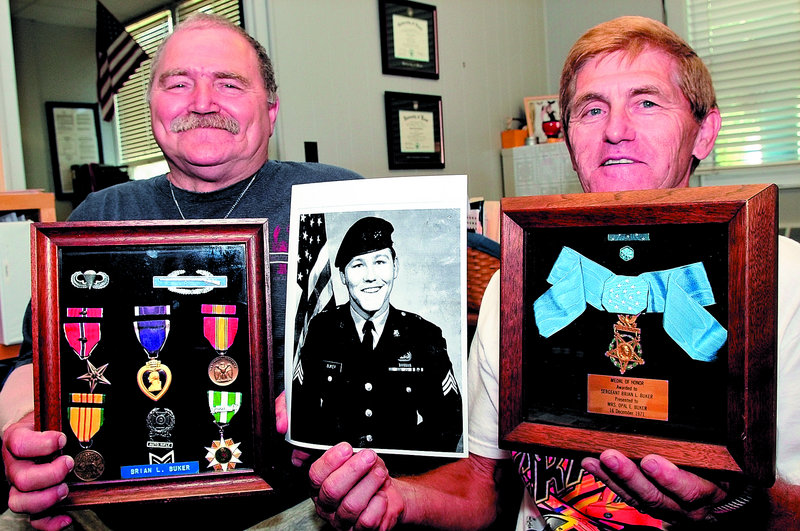 Victor Buker, left, and his brother Alan hold the Medal of Honor and other awards earned by their brother Brian Buker, shown in the photograph, who was killed in Vietnam while serving as a Green Beret in 1967. The Bukers are donating the war memorabilia to Lawrence High School in Fairfield.