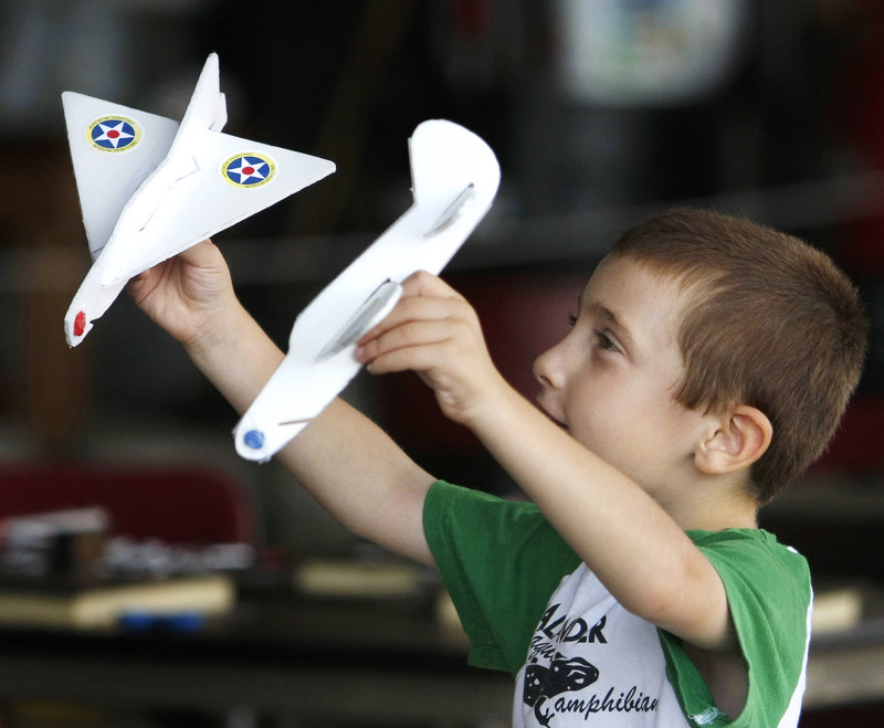 Five-year-old David Howard of Greenland, N.H., has some fun with model airplanes he made at the Vintage Motorcycle Meet and Antique Aeroplane Show. David and his family are spending the weekend in Camden for the Windjammer Festival.