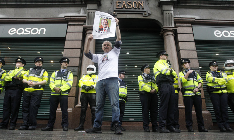 A protester demonstrates Saturday outside Eason’s bookstore in Dublin, where Tony Blair held the first public signing of his memoir, as Irish police look on. Hundreds lined up to get his autograph; opponents of his foreign policies chanted that he had “blood on his hands.”