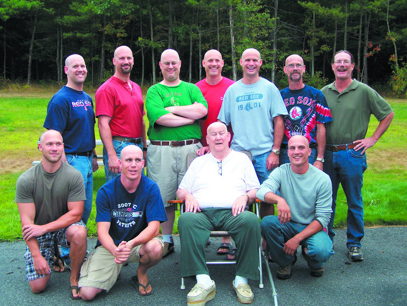 Russell Cotnoir Sr. is surrounded by sons and grandsons who shaved their heads last month in East Winthrop. One son, Chris, at back right, kept his hair because he’s growing it out for a donation to Locks of Love. He shaved his beard instead.