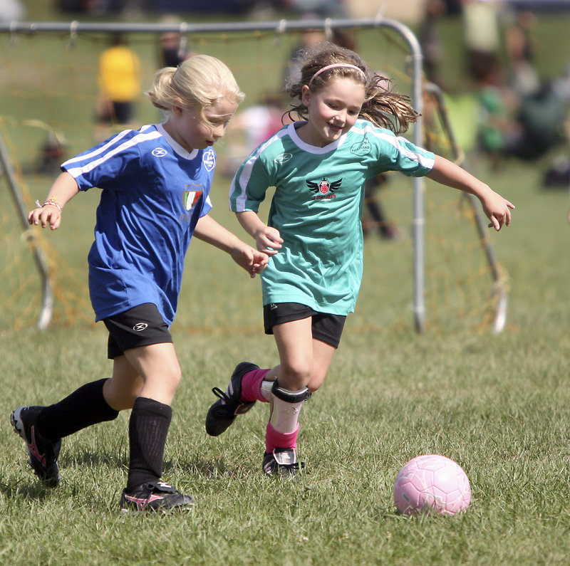 Katie Lederer of Italy, left, defends against Georgia Listell of Japan during their U8 match. U8s play 5 vs. 5 without keepers to reward end-to-end action.