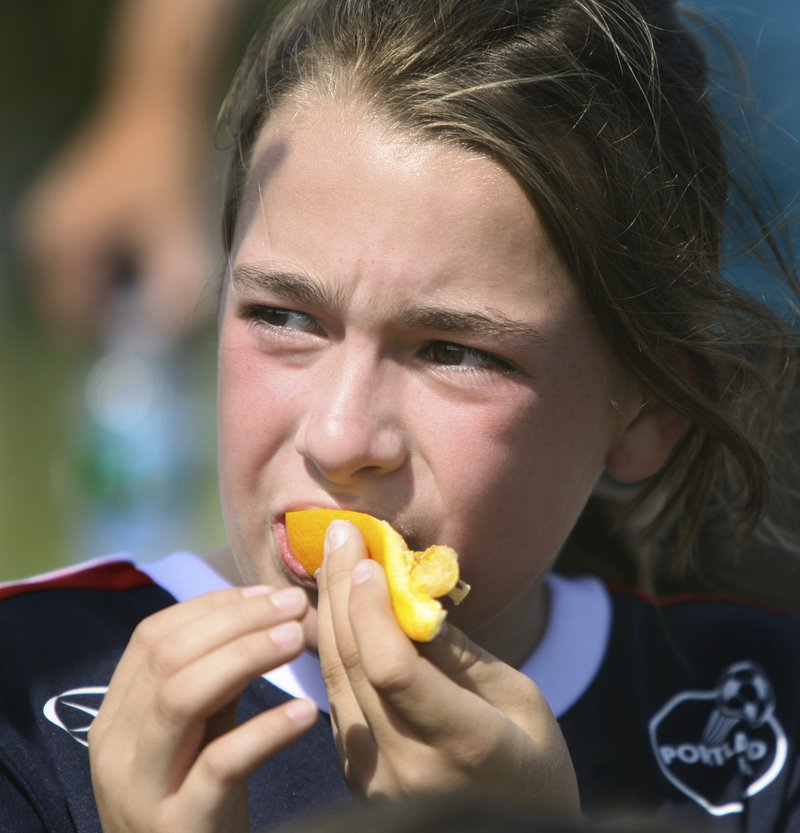 Molly Page of USA enjoys an orange slice at halftime of her U10 match with Brazil on Monday. Is there any better halftime snack?