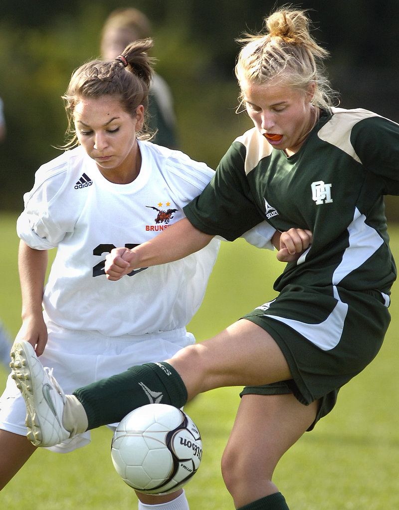Becky Champagne of Brunswick, left, contends for control of the ball against Lacey Landry of Oxford Hills. Dakota Foster scored twice for Brunswick in its victory.