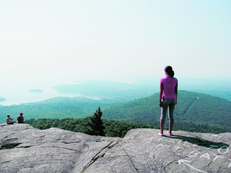 A 12-year-old hiker is rewarded with the view of bay and mountains from Ocean Lookout, at 1,300 feet, on Mount Megunticook.